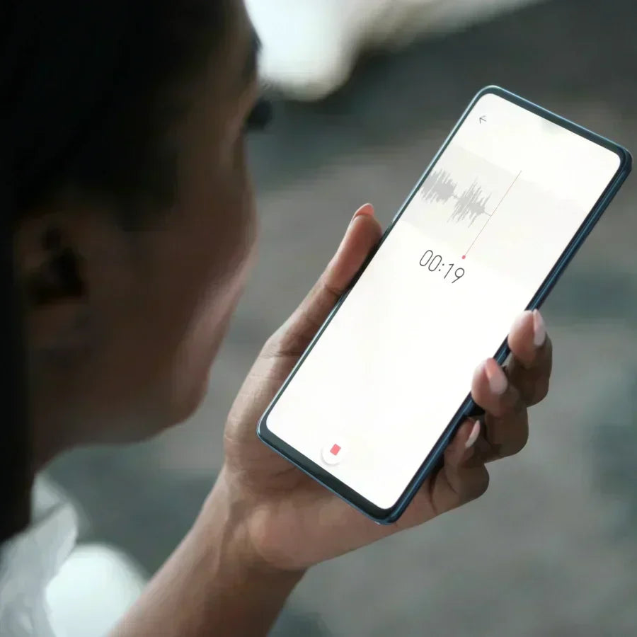 Eine Person nutzt die Plaud App auf einem Smartphone für eine Audioaufnahme mit sichtbarer Wellenform.