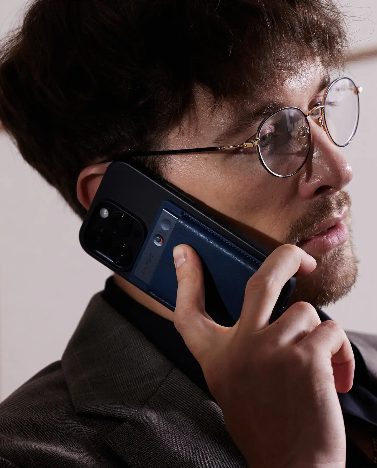 Blauer Plaud Note KI-Audiorekorder auf der Rückseite eines Smartphones während eines Telefonats.