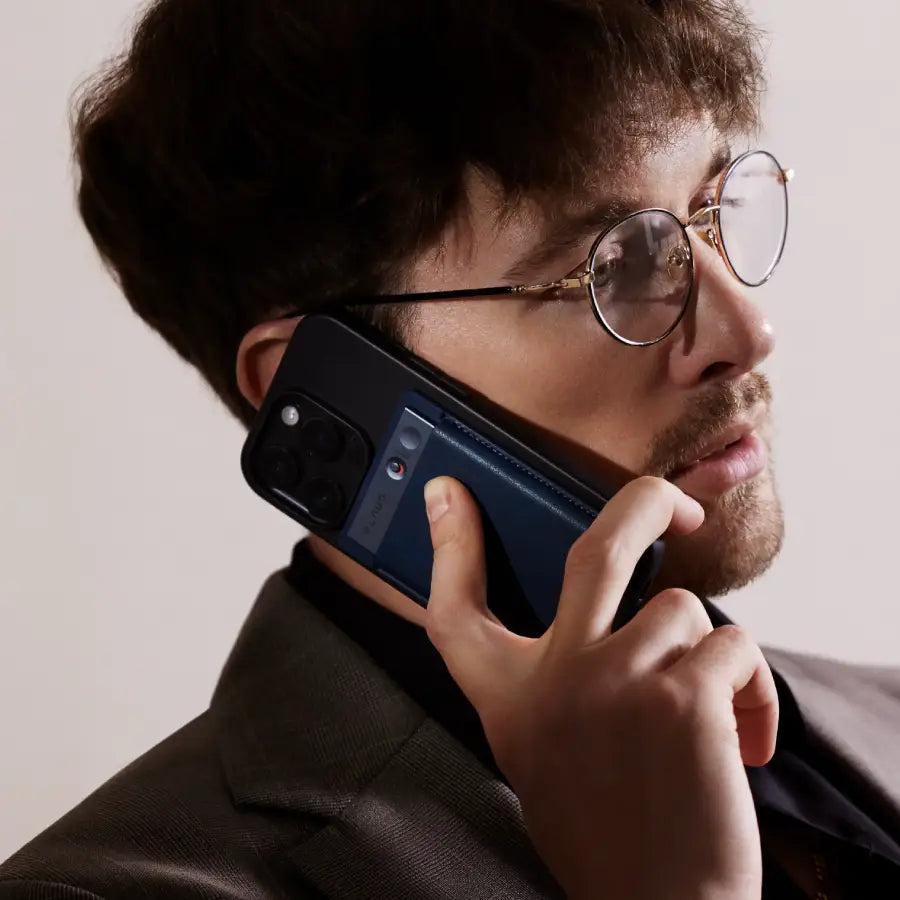 Ein Mann nutzt den blauen Plaud Note an seinem Smartphone, um ein Telefongespräch aufzuzeichnen.