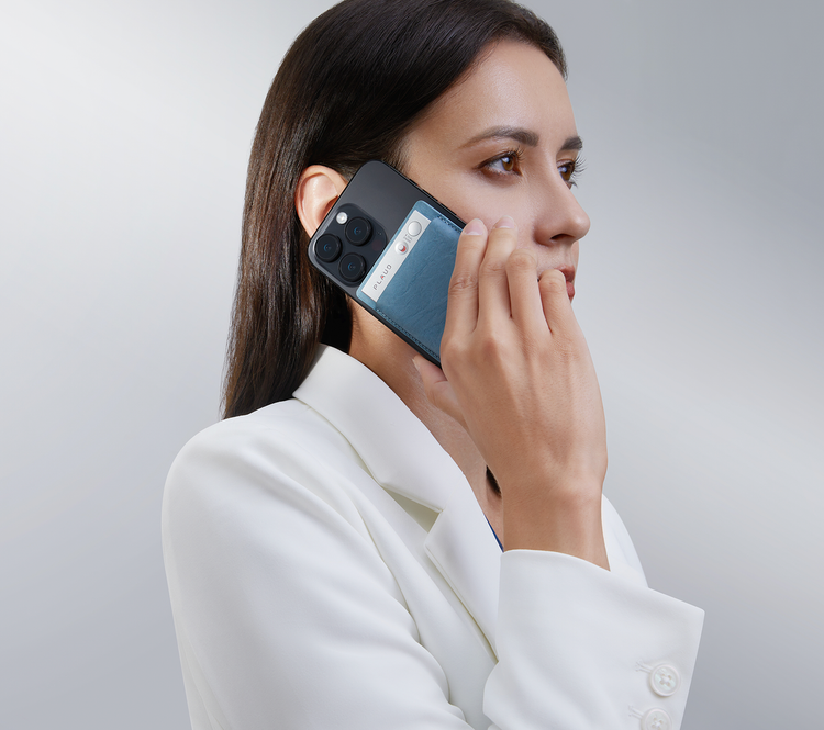 Frau nutzt einen silbernen Plaud Note in blauer Hülle an ihrem Smartphone, um ein Telefonat aufzuzeichnen.