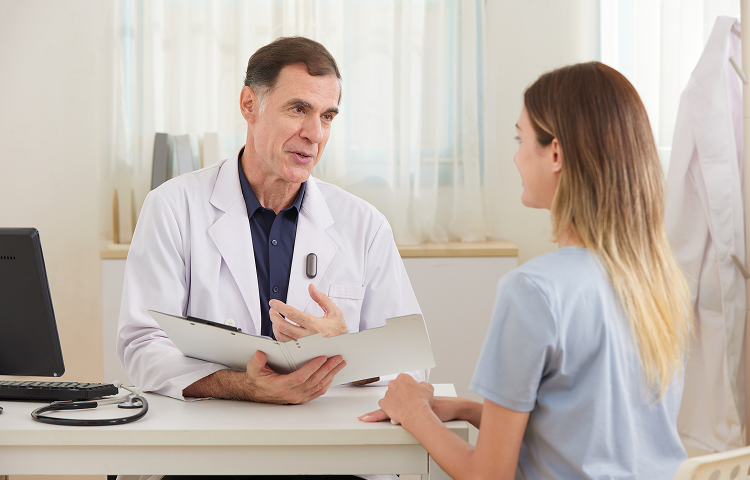 Ein Arzt trägt ein Plaud NotePin am Revers während eines Beratungsgesprächs mit einer Patientin.