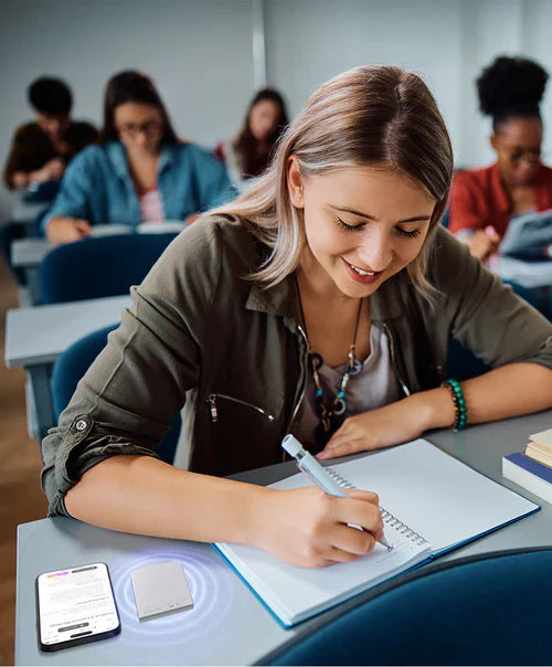 Eine Studentin nutzt den silbernen Plaud Note in einer Vorlesung zur Audioaufnahme neben ihrem Smartphone.